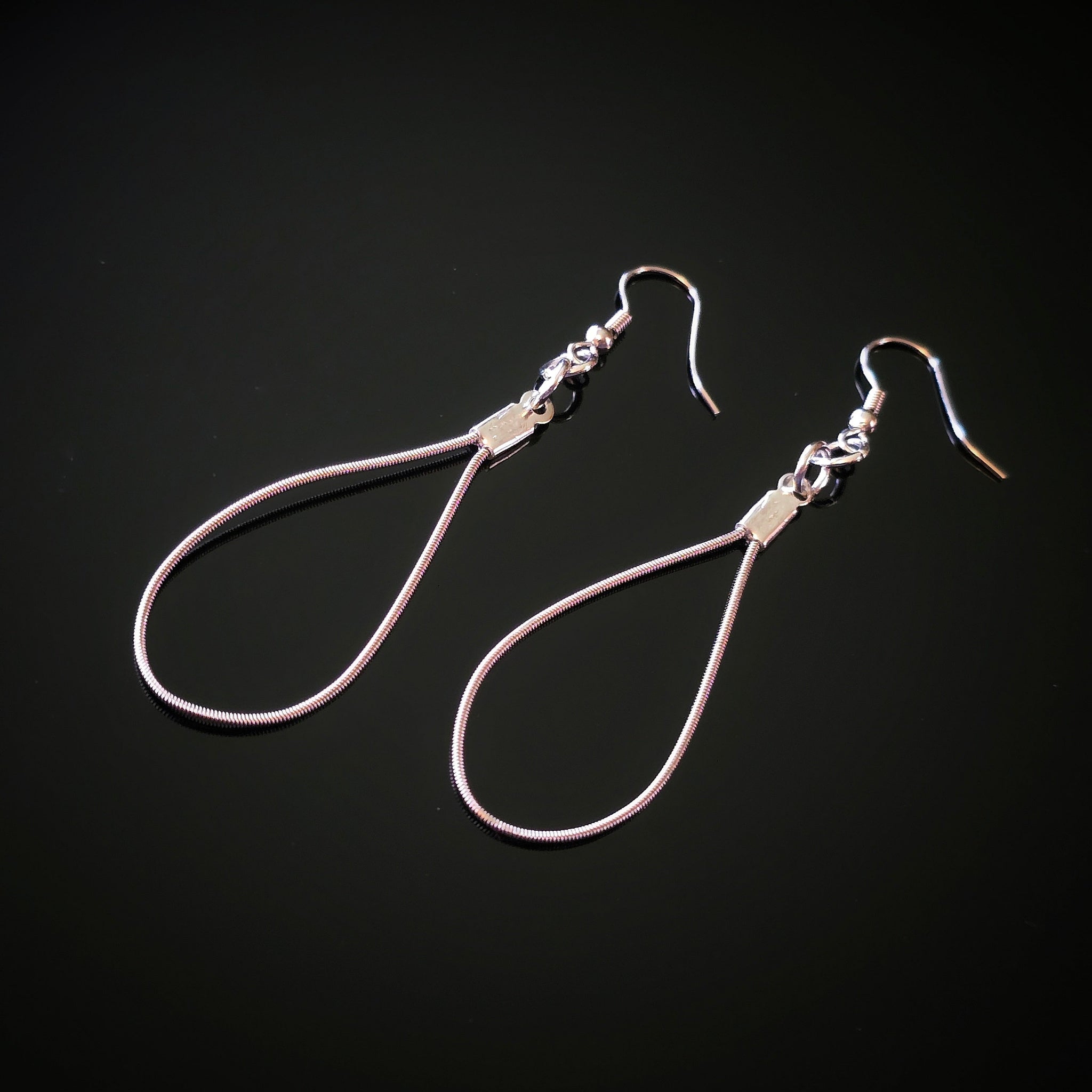 Teardrop Guitar String Earrings on Black Background 