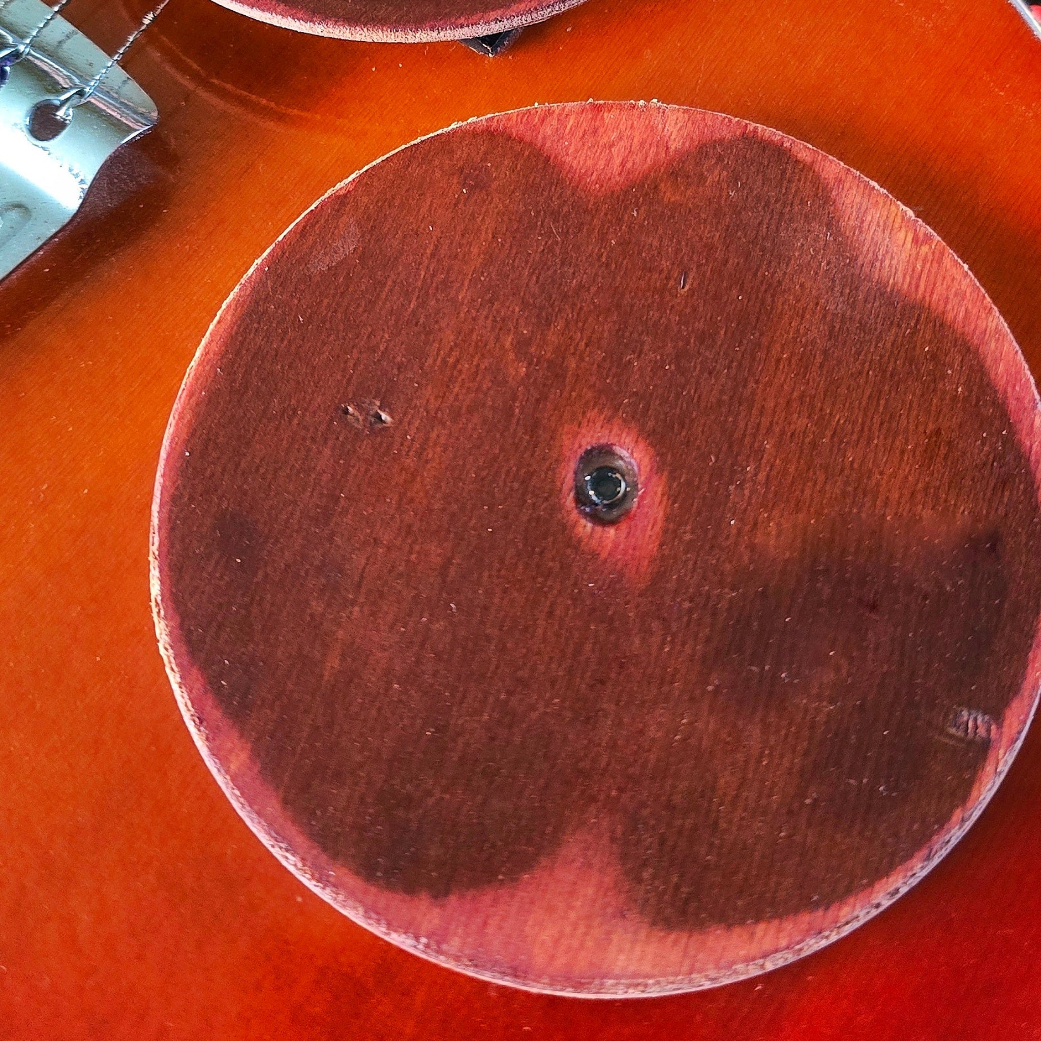 Two round coasters made from guitar wood on a guitar 