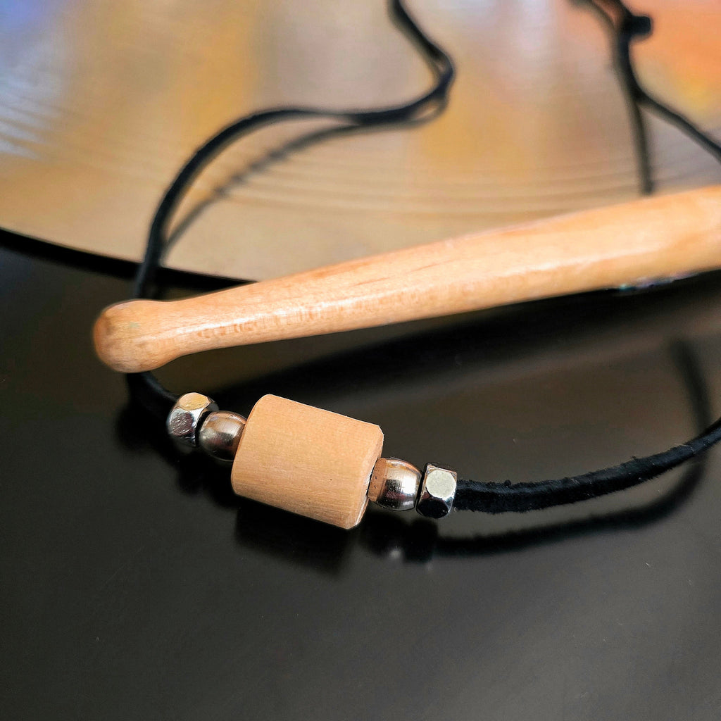 Upcycled Drumstick and Black Suede Necklace With Smooth Silver Beads Drumstick and Cymbal in Background