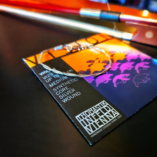 Violin bow string with an upcycled viola string bracelet on a viola string packaging
