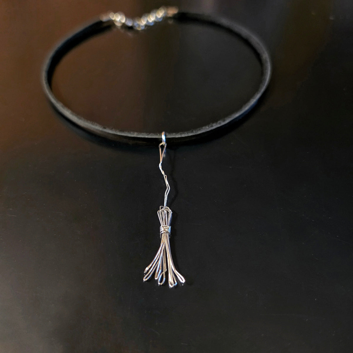 Witch's Broom Guitar String and Black Leather Choker on Black Background