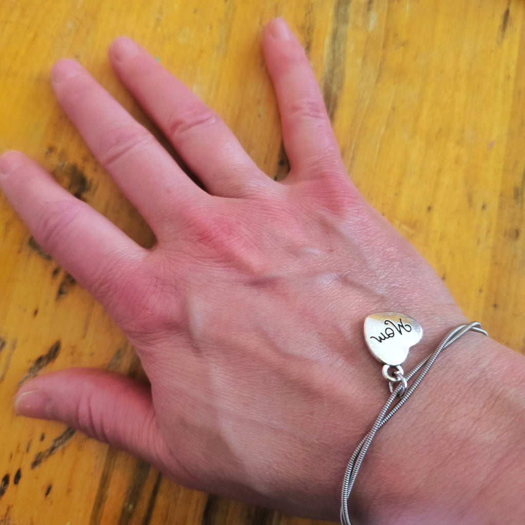 Woman's hand wearing Guitar String Mom Charm Bracelet
