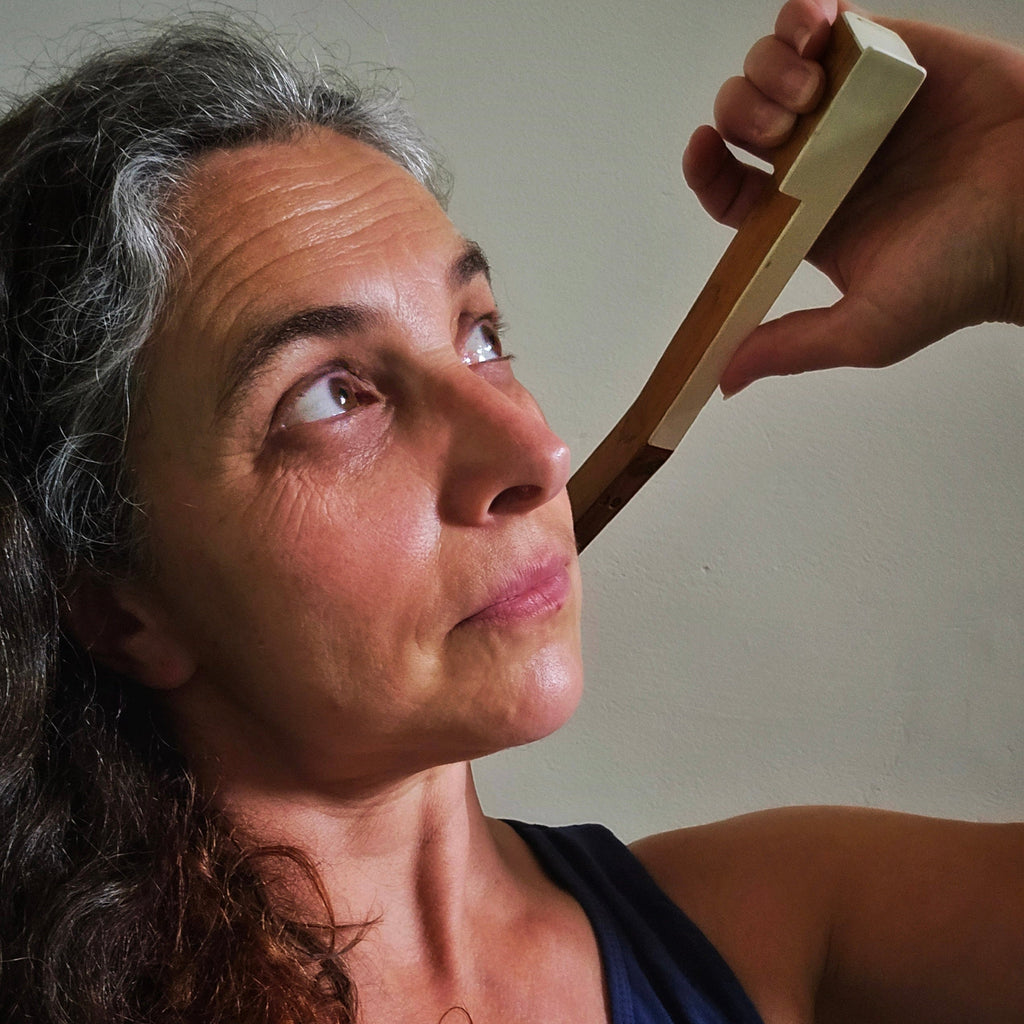 Woman's head and shoulders, using an upcycled piano key backscratcher 