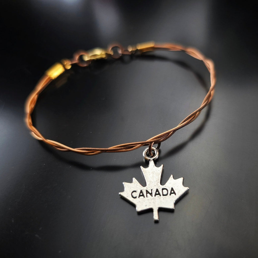 bronze coloured guitar string bracelet with canada maple leaf pendant