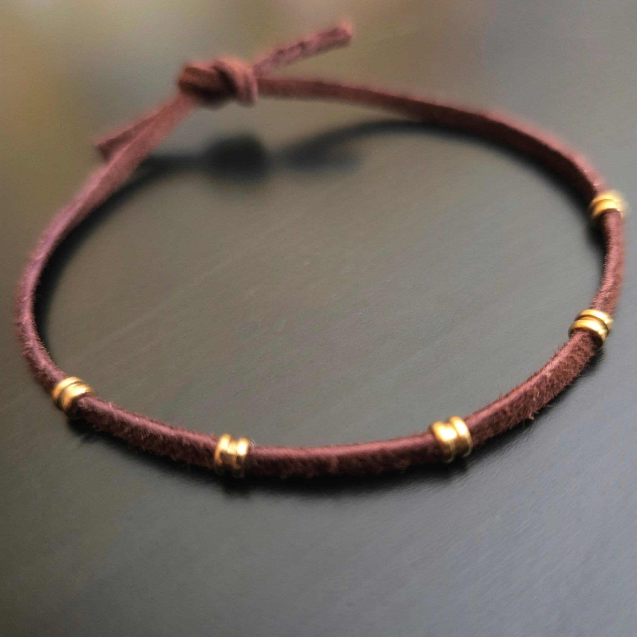 closeup of brown suede and guitar string ballend adjustable bracelet