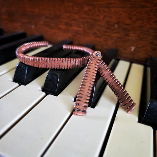 Upcycled Piano String Bracelets and Earrings Set on a piano 