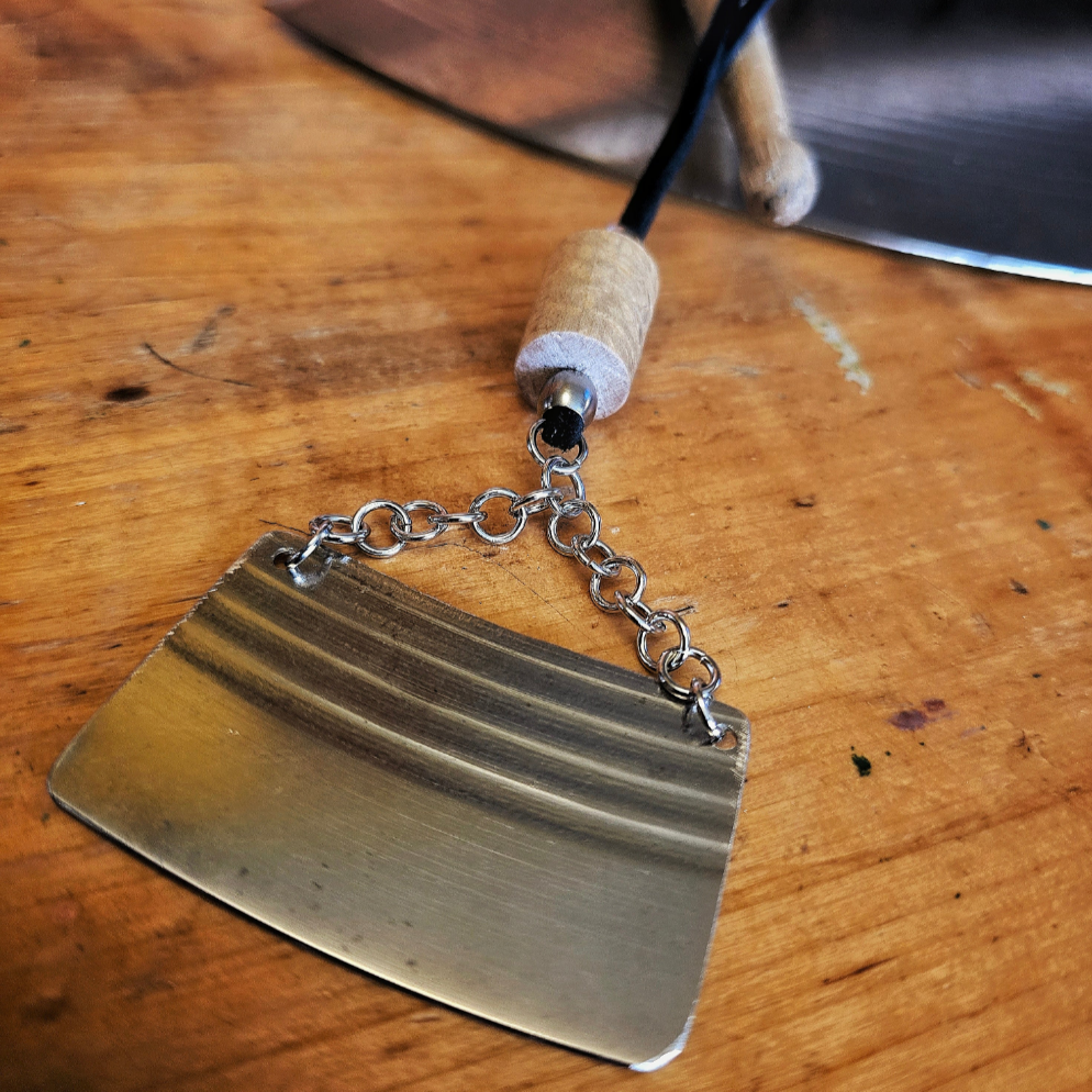cymbal piece and drumstick necklace on black suede cord necklace