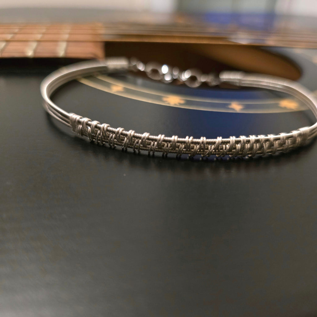 woven guitar string bracelet on guitar