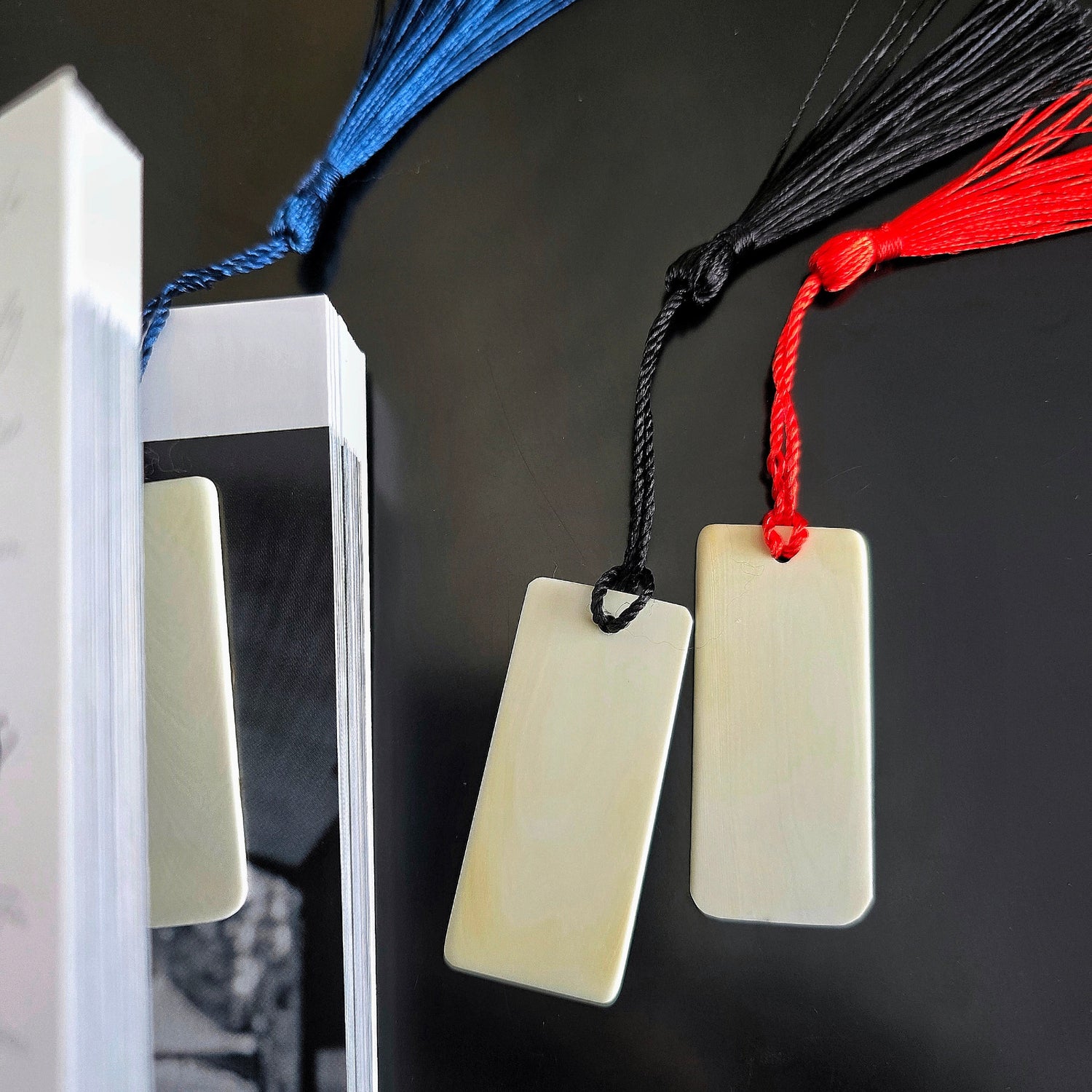 Three ivory piano key bookmarks in and beside a book