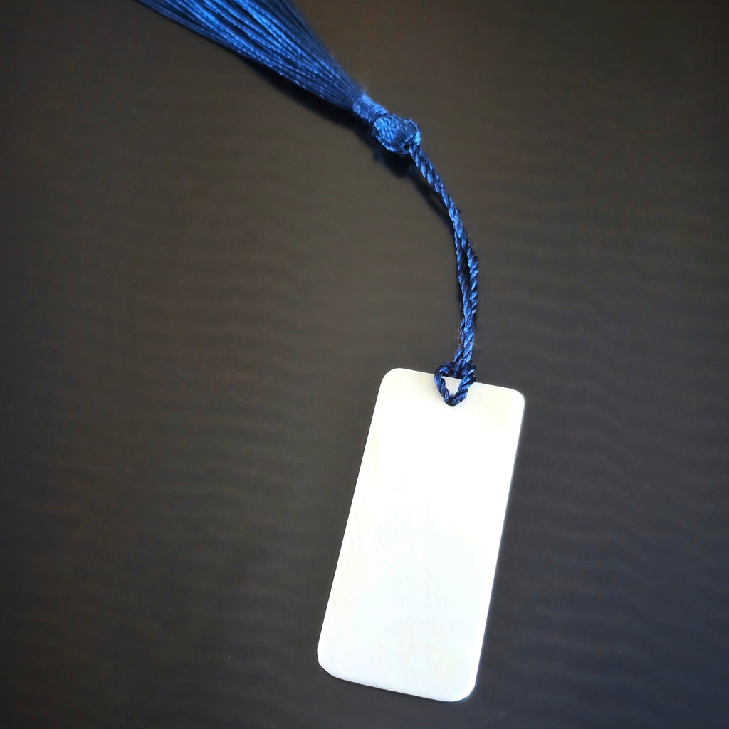 ivory piano key topper bookmark with blue tassel on black background