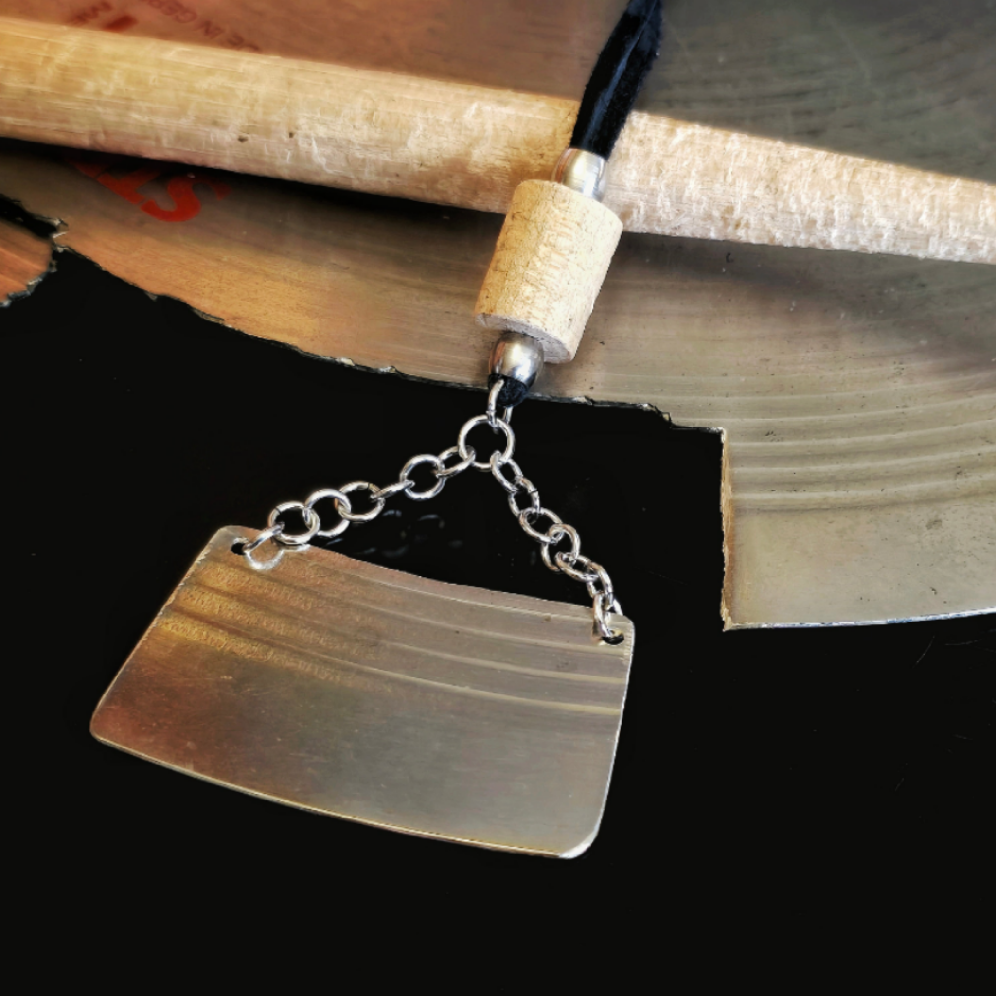 necklace made from black suede cord and upcycled cymbal and drumstick pieces with closeup of cymbal and drumstick
