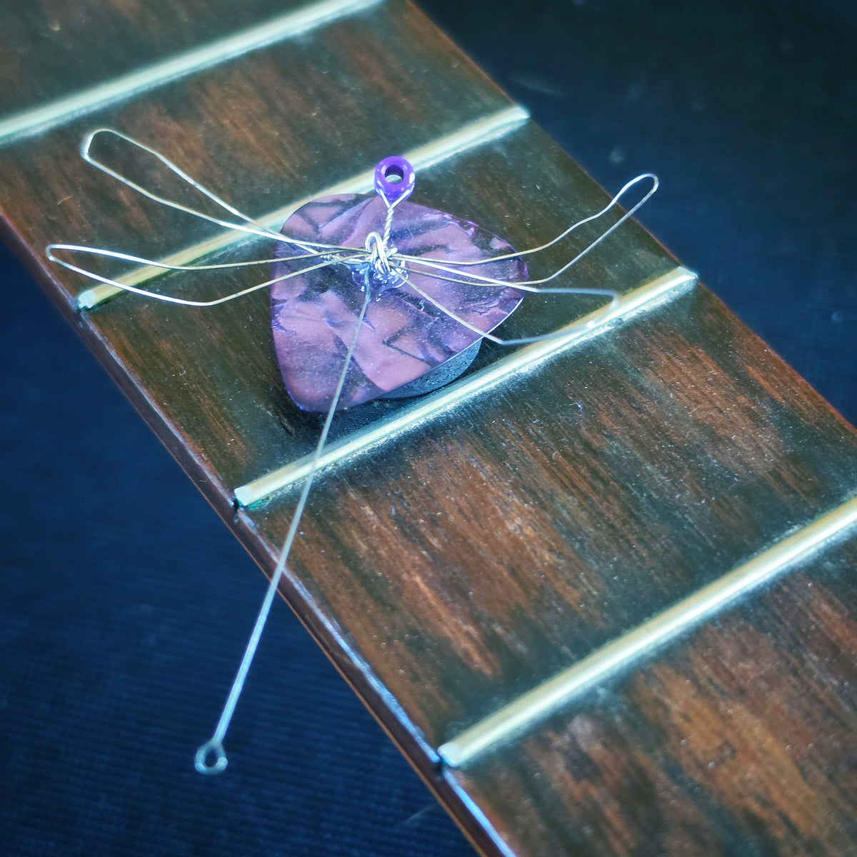 Aimant libellule en corde et plectre mauve de guitare