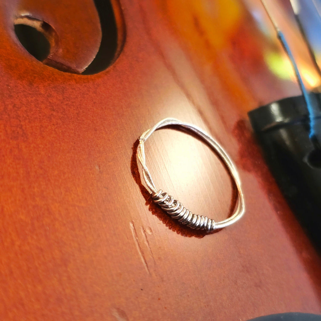 side view of violin string ring on a violin surface