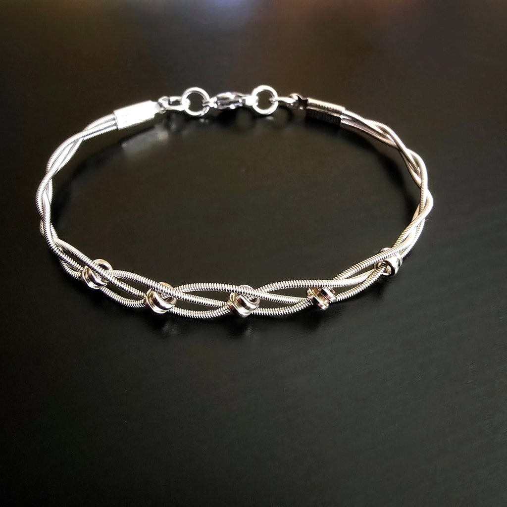 upcycled silver guitar string bracelet black background