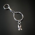 silver coloured keychain made from an upcycled guitar string with a silver coloured ribbon shaped charm with the word HOPE etched on it