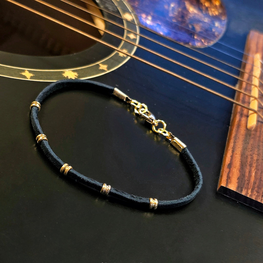 black suede and guitar strings ballend bracelet on black guitar