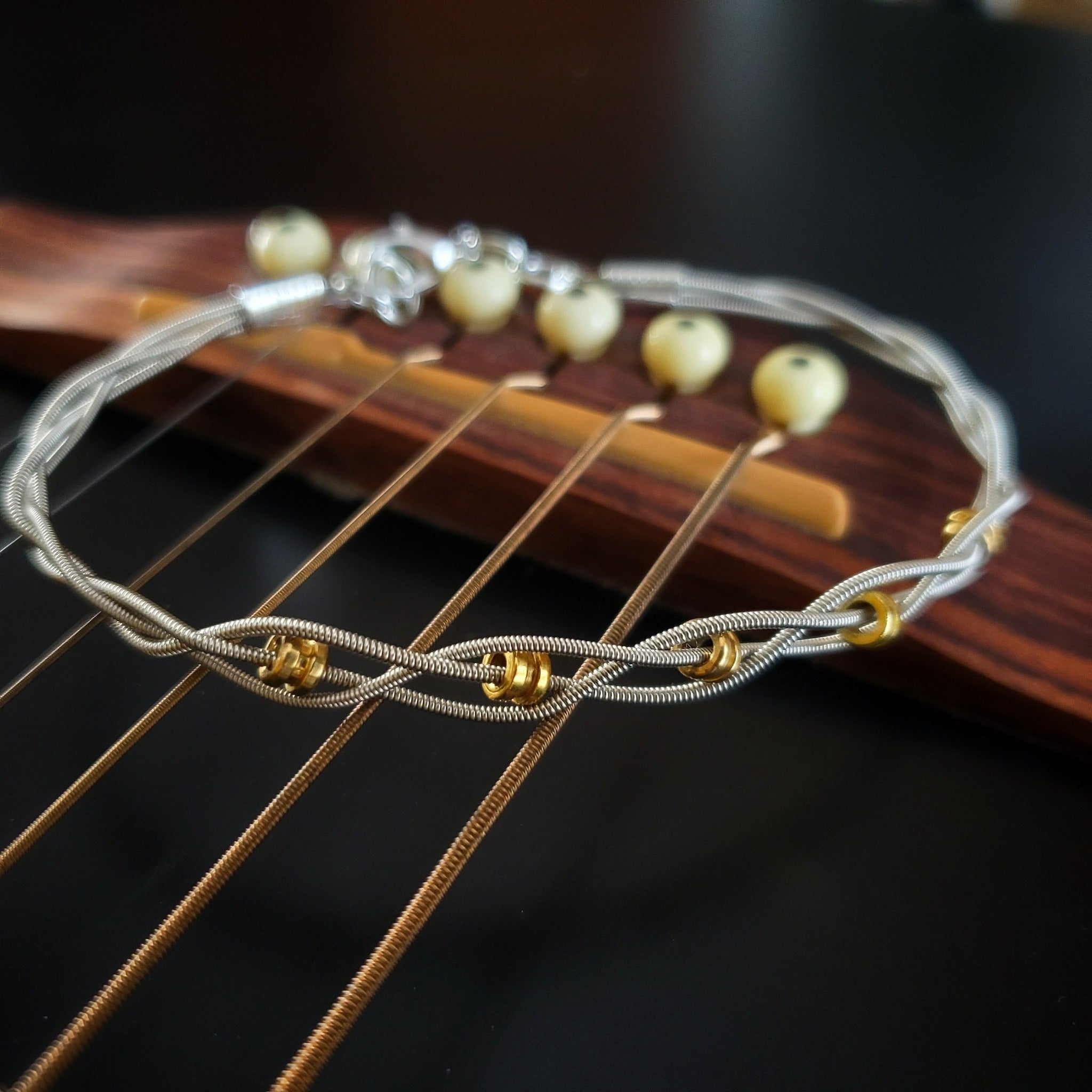 upcycled gold and silver guitar string bracelet on guitar strings
