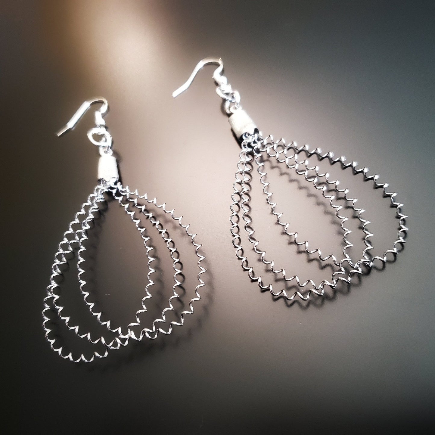 teadrop style silver earrings made from upcycled snare drum strings