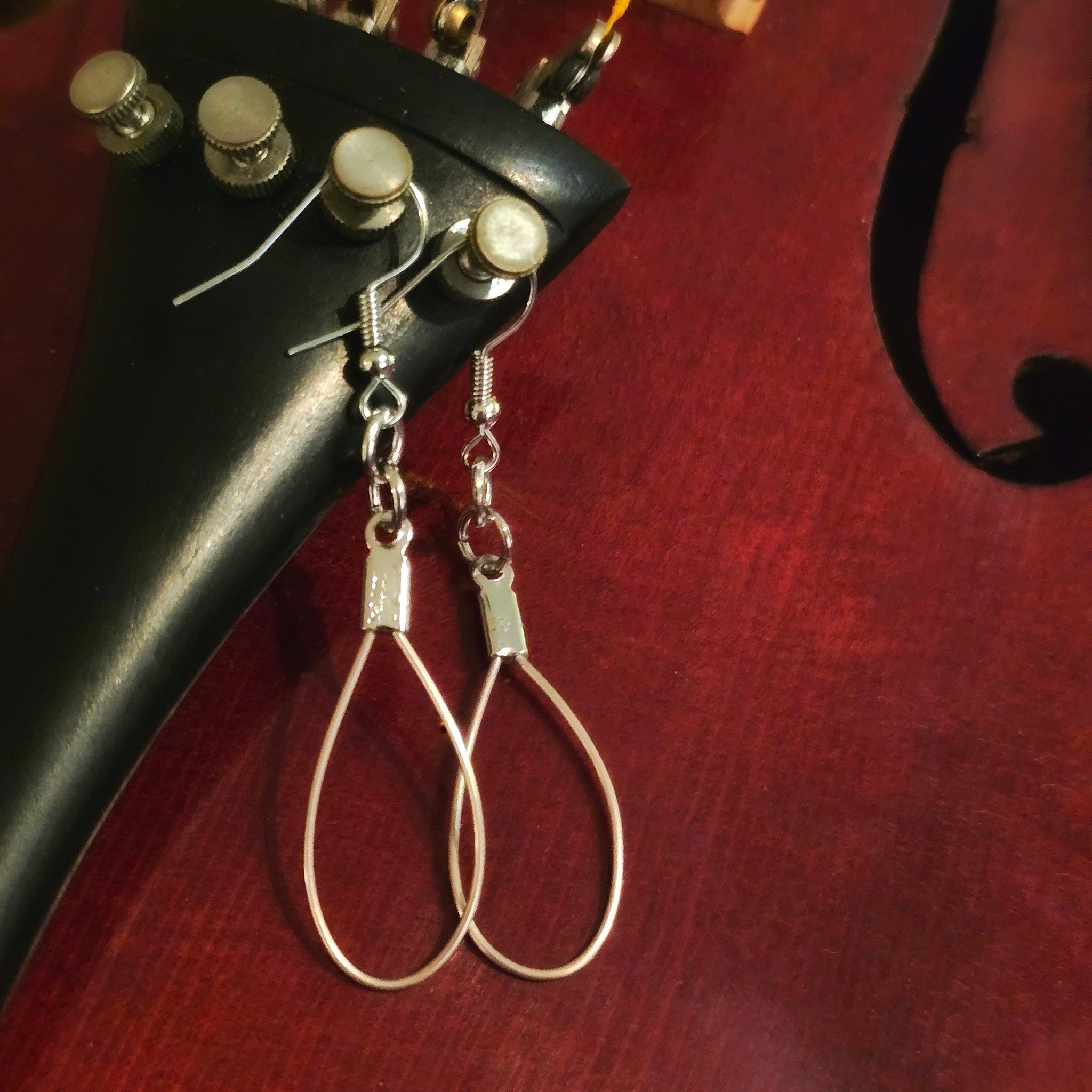 upcycled violin string earrings hanging off violin hardware