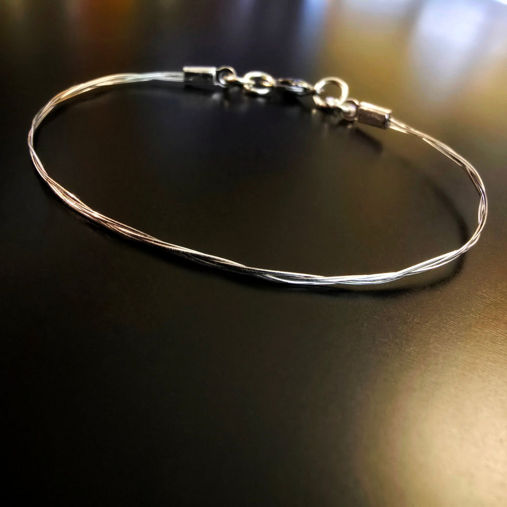 violin string bracelet on black background