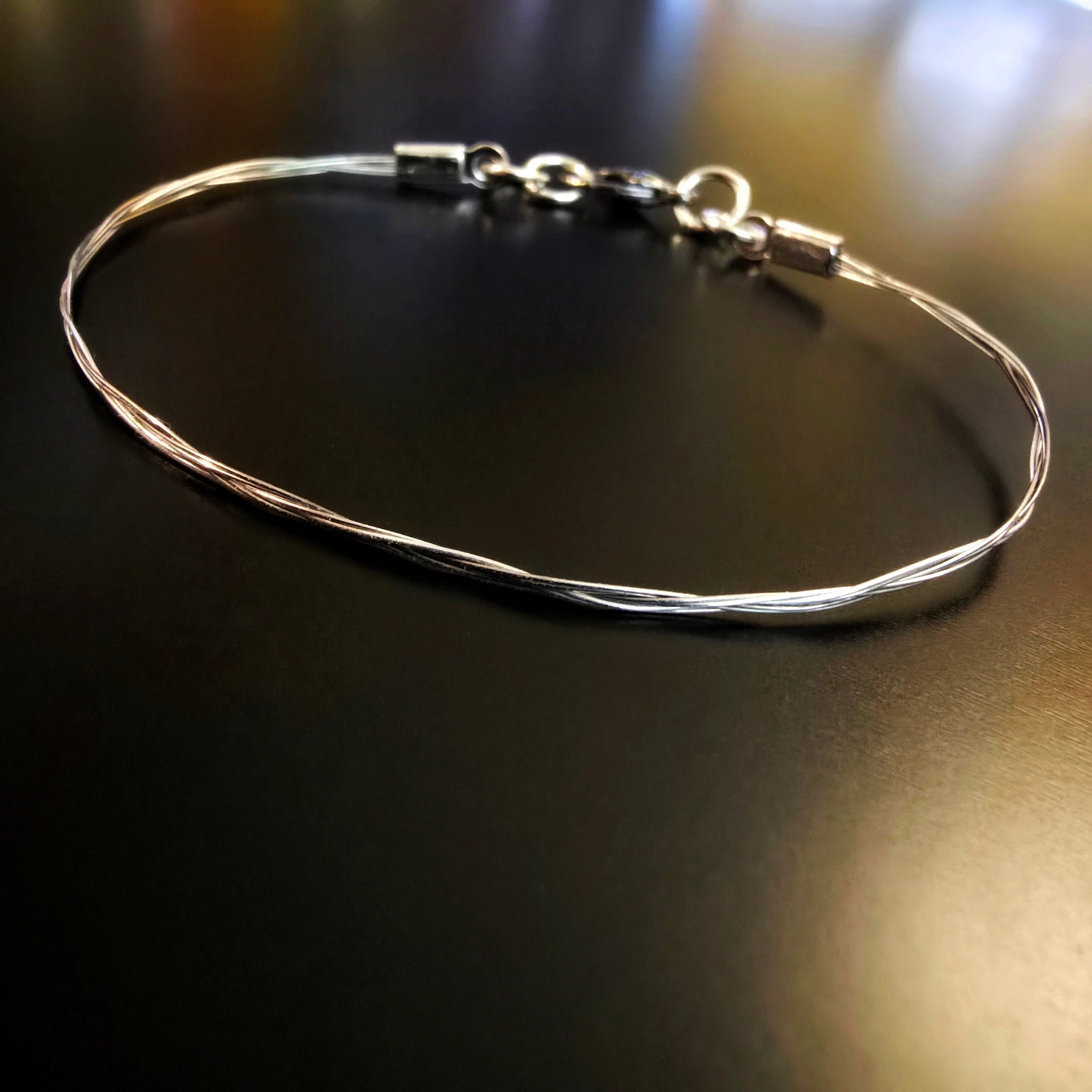 violin string bracelet on black background