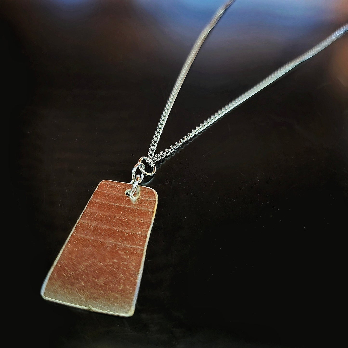 dog tag style upcycled cymbal piece necklace black background 