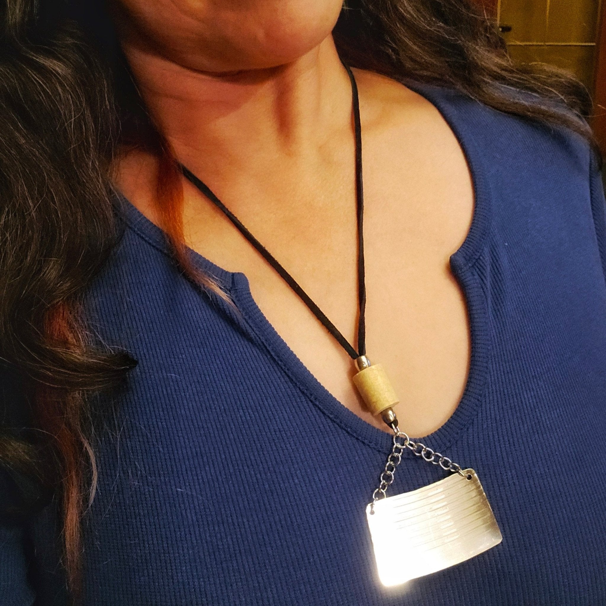 woman wearing cymbal piece and drumstick black suede necklace 