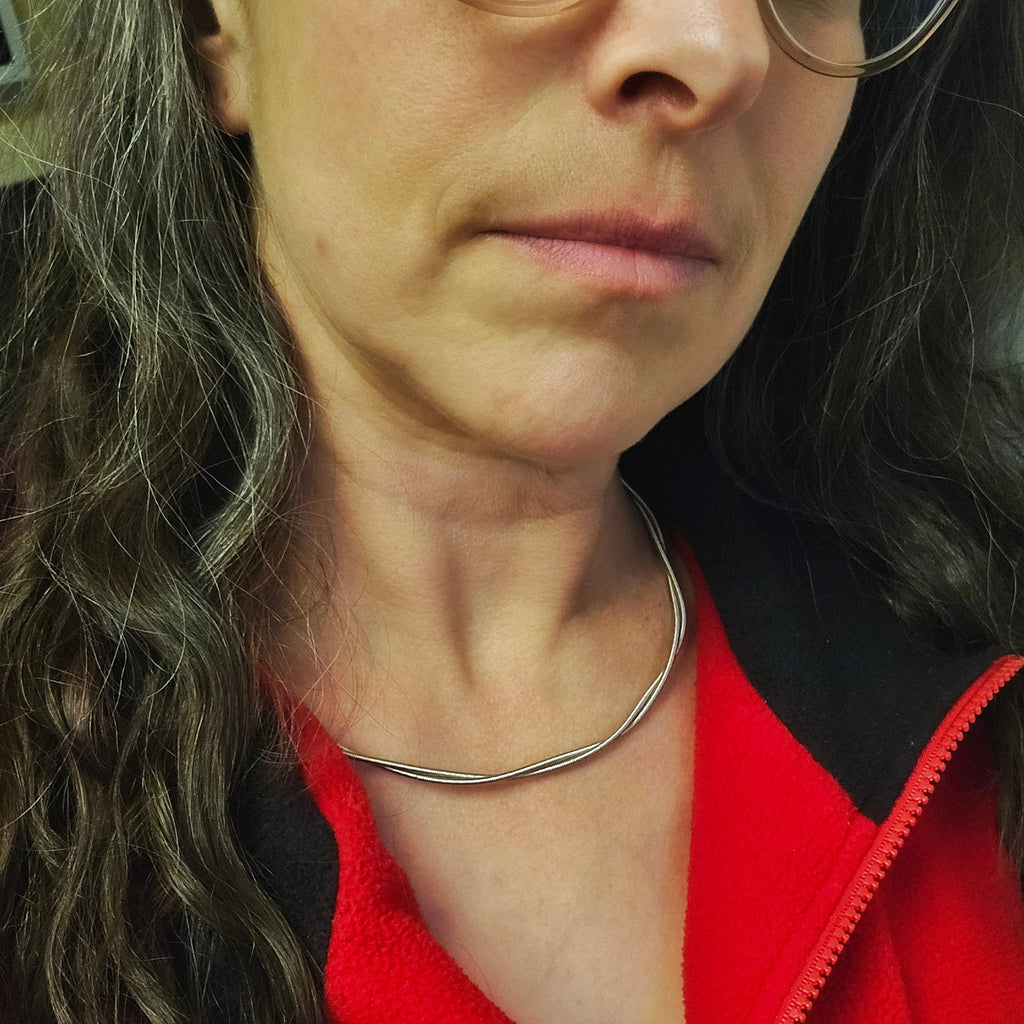 woman wearing person wearing electric bass guitar string necklace 