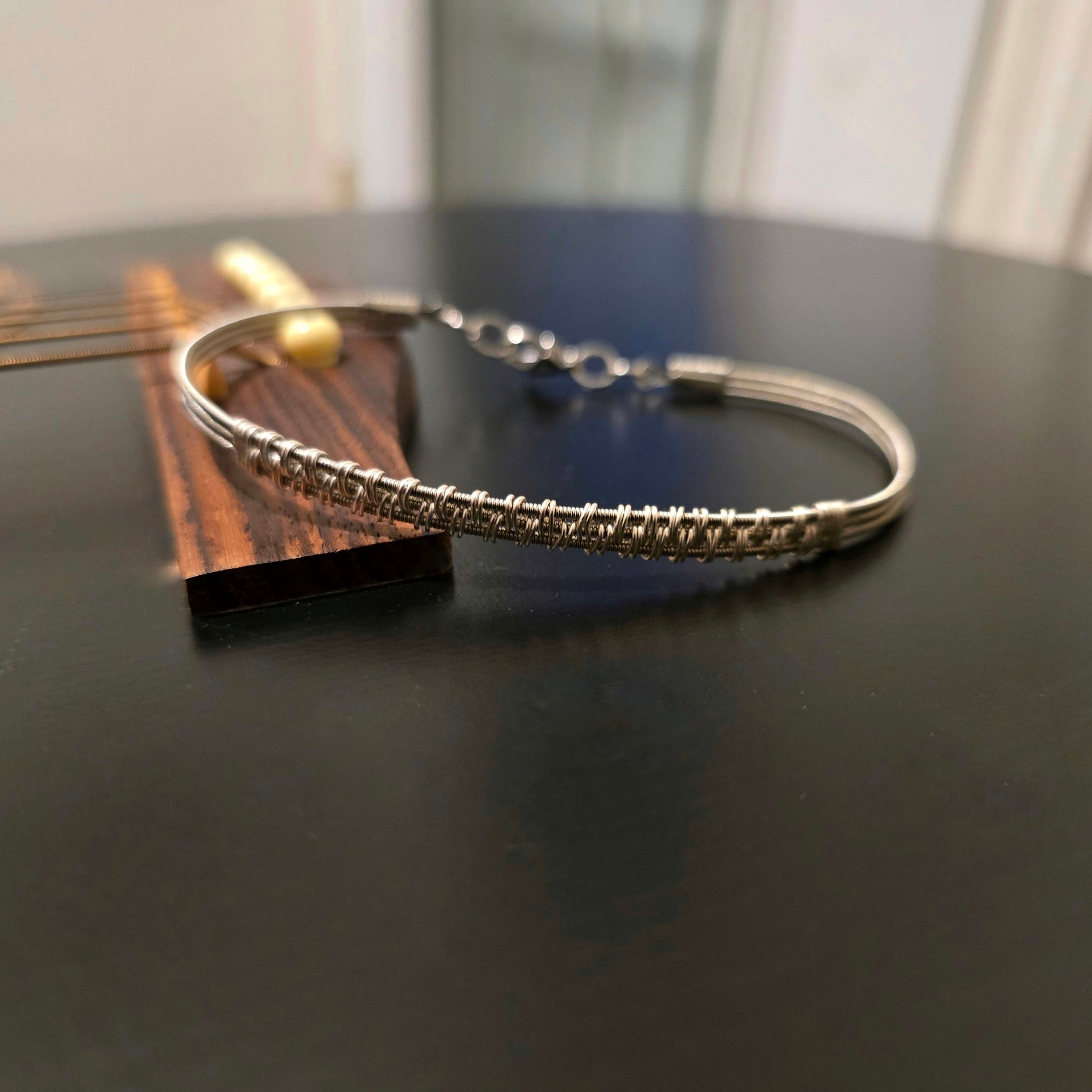 woven guitar bracelet on black guitar