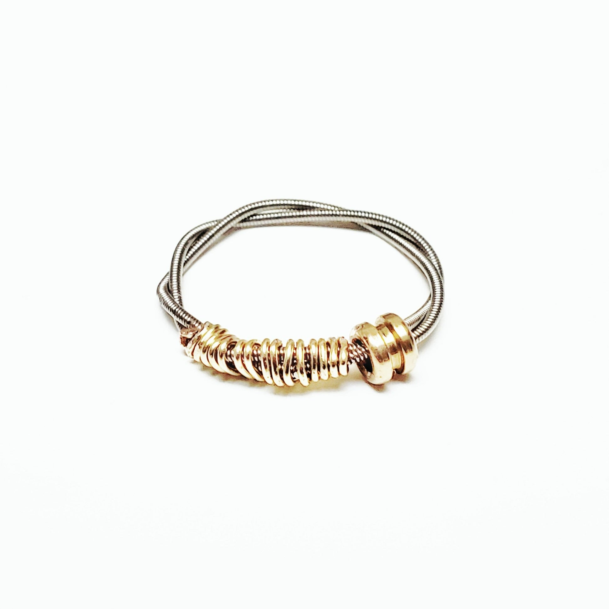 guitar string fidget ring with a gold coloured ballend - white background