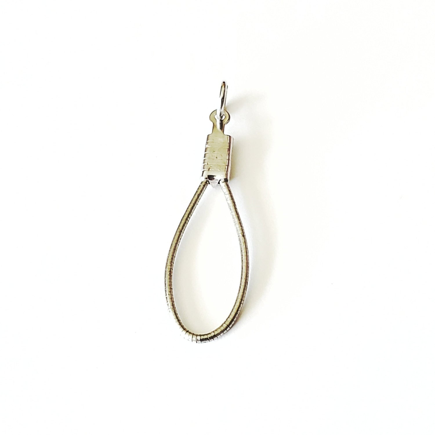 a silver coloured pendant made from an upcycled cello string - white background