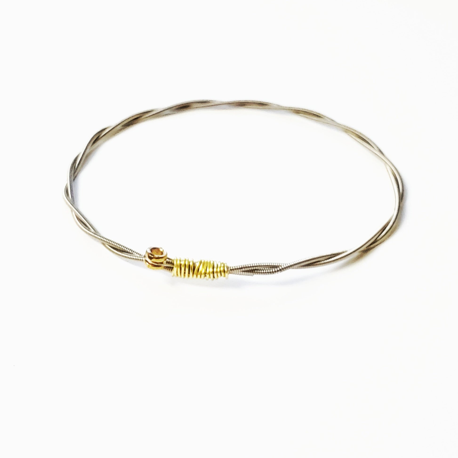 bangle style bracelet made from an upcycled guitar string - white background