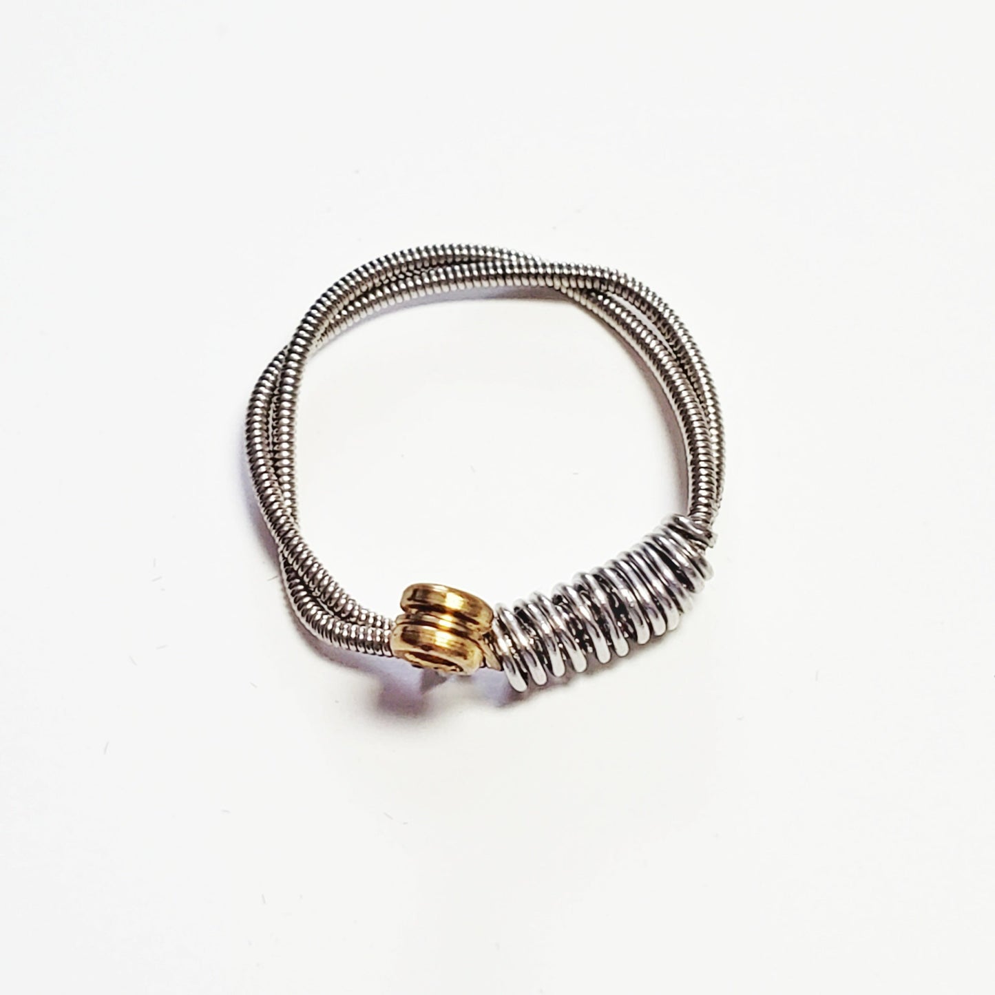 a silver coloured guitar string ring - white background