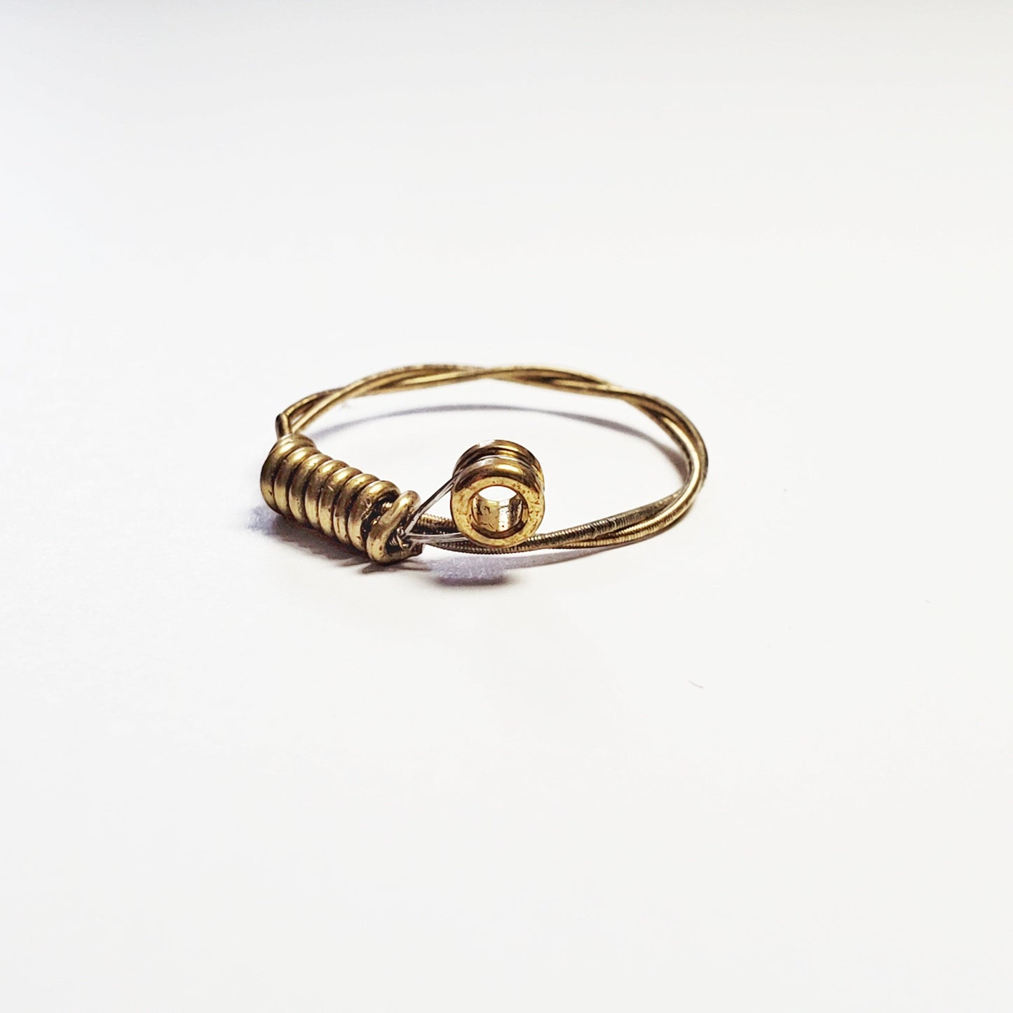a gold coloured guitar string ring - white background