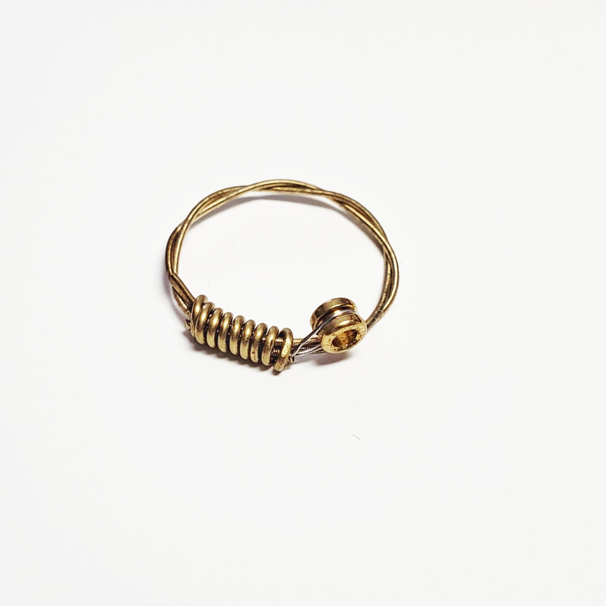a gold coloured guitar string ring - white background