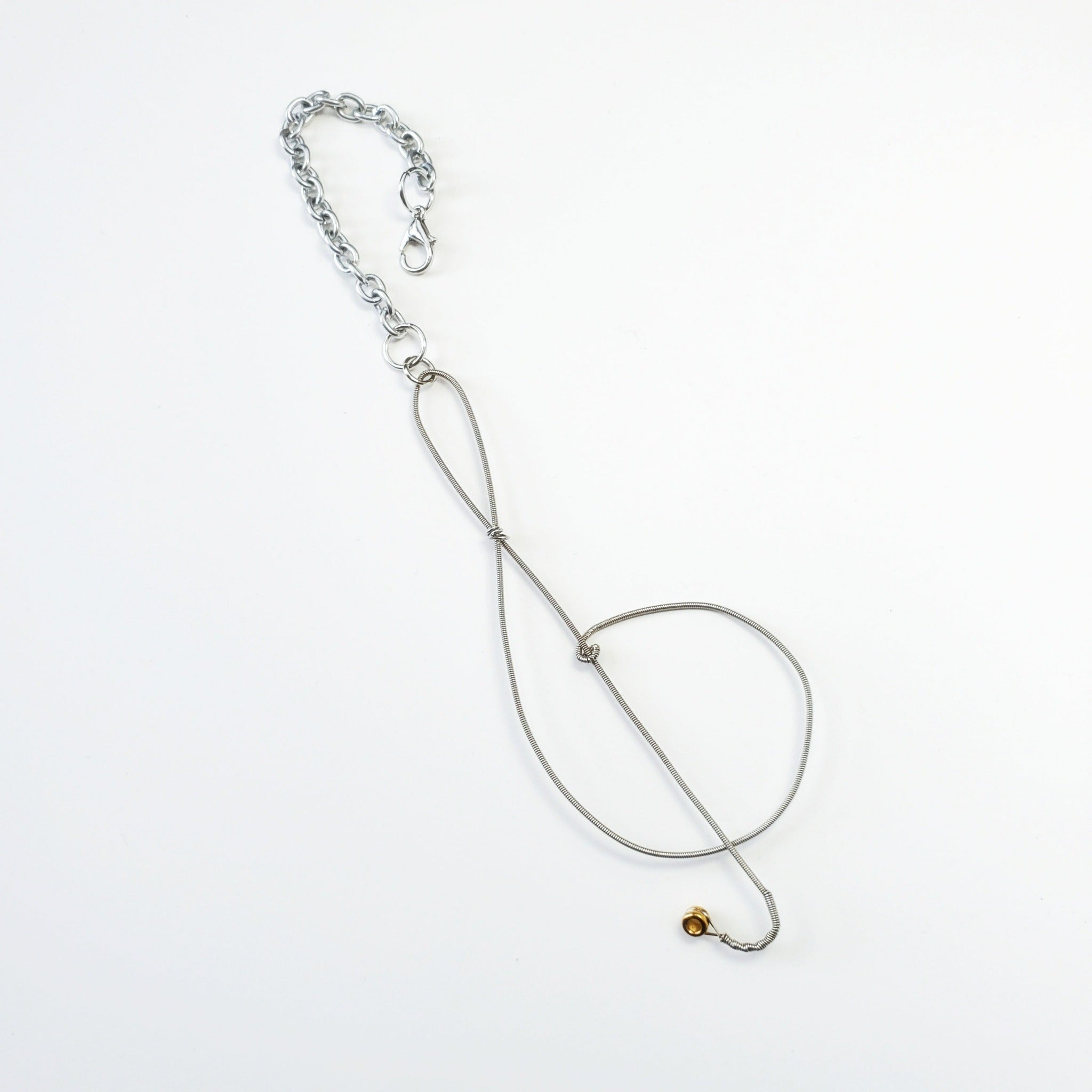 rearview mirror decoration in the shape of a treble clef, made from an upcycled guitar string