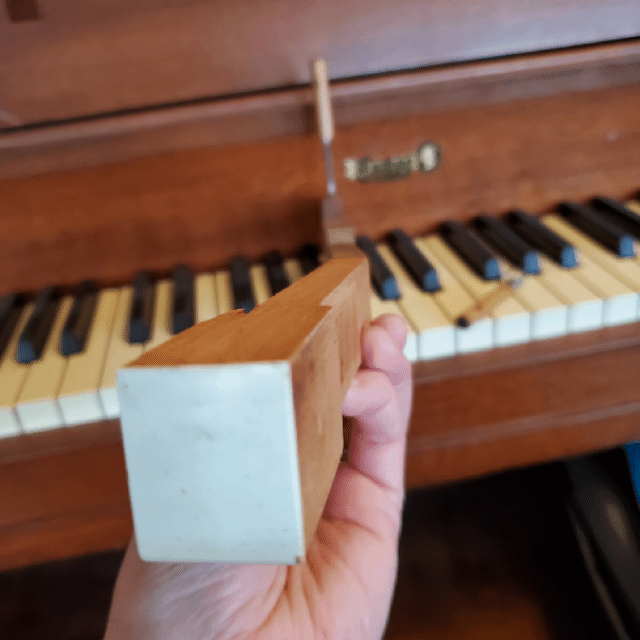 video of a piano key zooming into the part that was used to create the keychain in the last frame as it sits on a piano keyboard