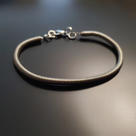 silver coloured clasp style bracelet made from an upcycled electric bass guitar string