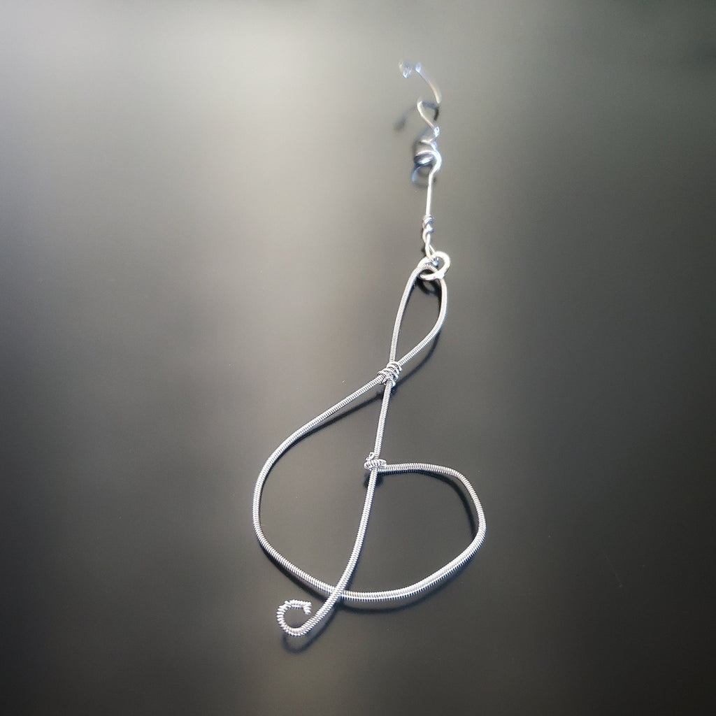 Christmas ornament in the shape of a treble clef, made from an upcycled guitar string