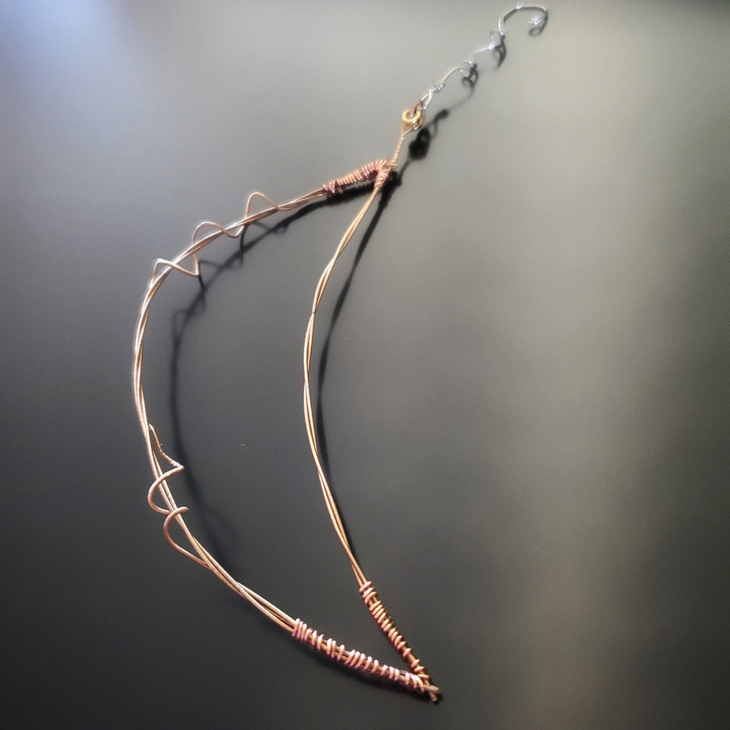 moon shaped Christmas ornament made from an upcycled guitar string 