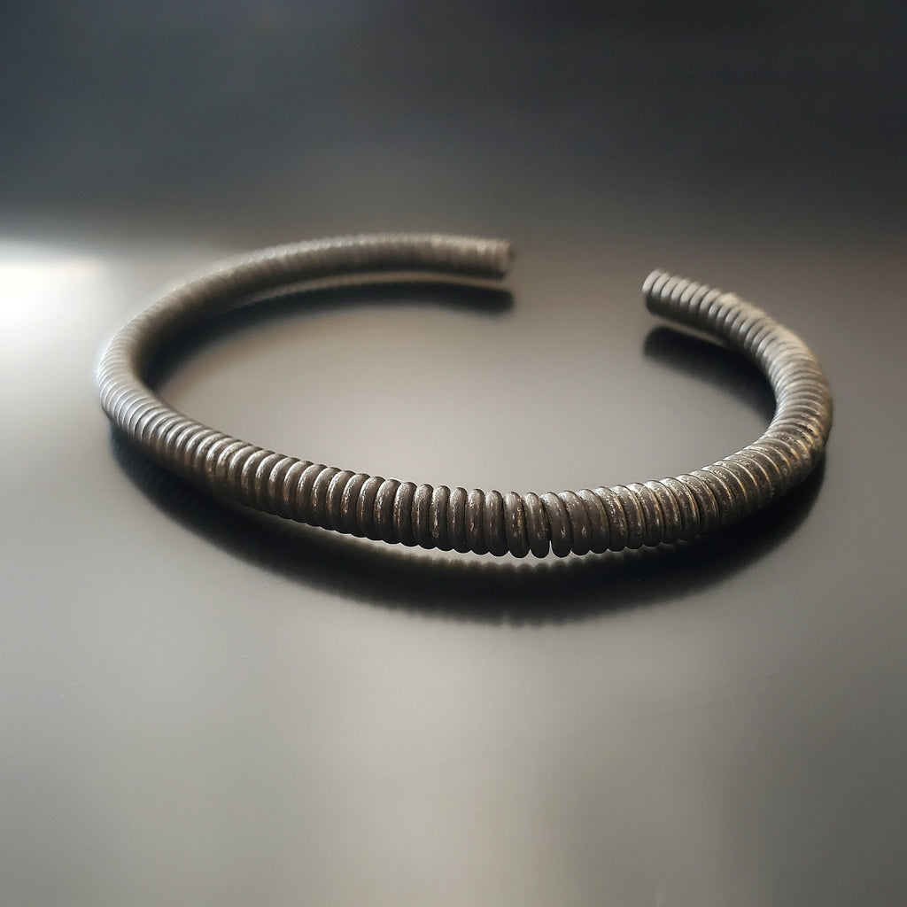 charcoal grey cuff style bracelet made from an upcycled piano string