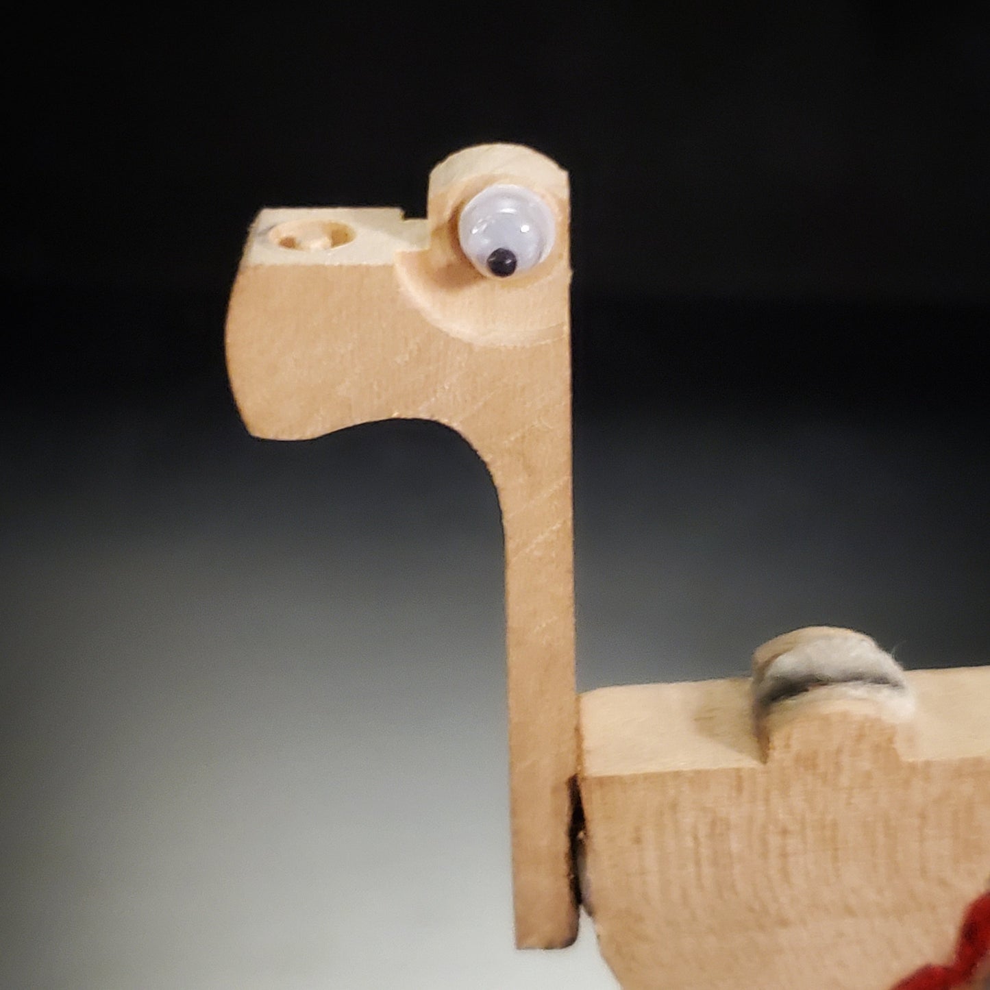 close-up of a a magnet in the shape of a dinosaur-like animal made from pieces of a piano mechanism