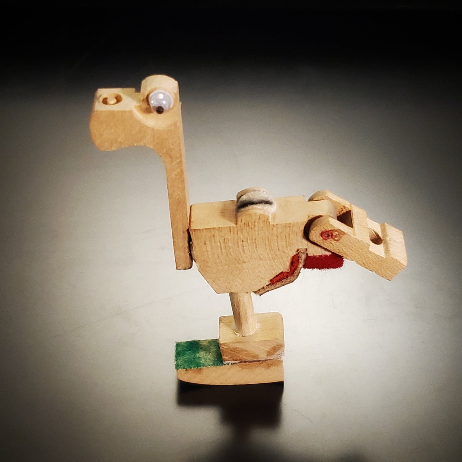 a magnet in the shape of a dinosaur-like animal made from pieces of a piano mechanism