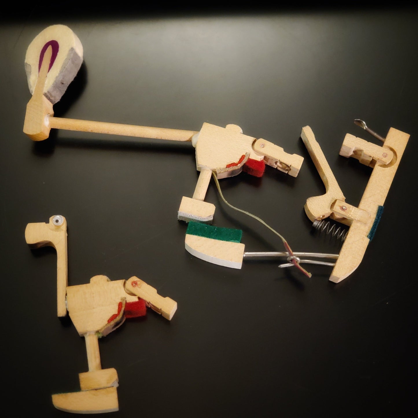 a magnet in the shape of a dinosaur-like animal made from pieces of a piano mechanism - above are the pieces of piano mechanism  like those from which it was made
