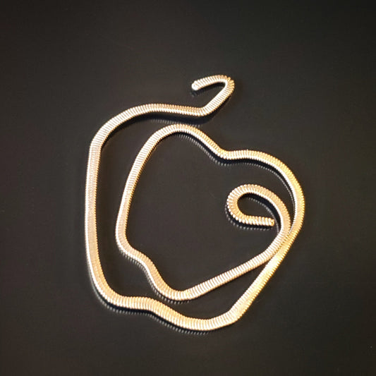 gold coloured guitar string bookmark teacher gift shaped like an apple on a black background