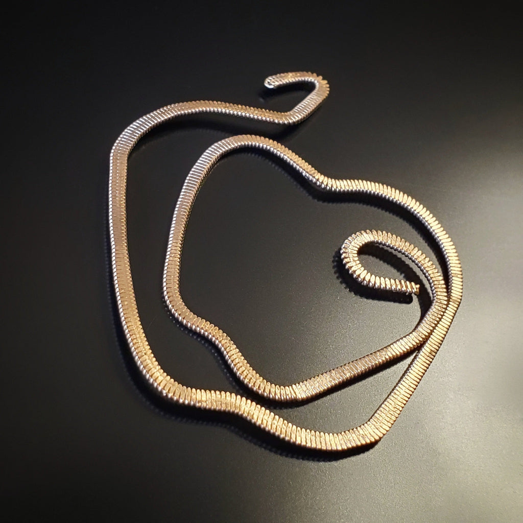 gold guitar string bookmark shaped like an apple on a black background
