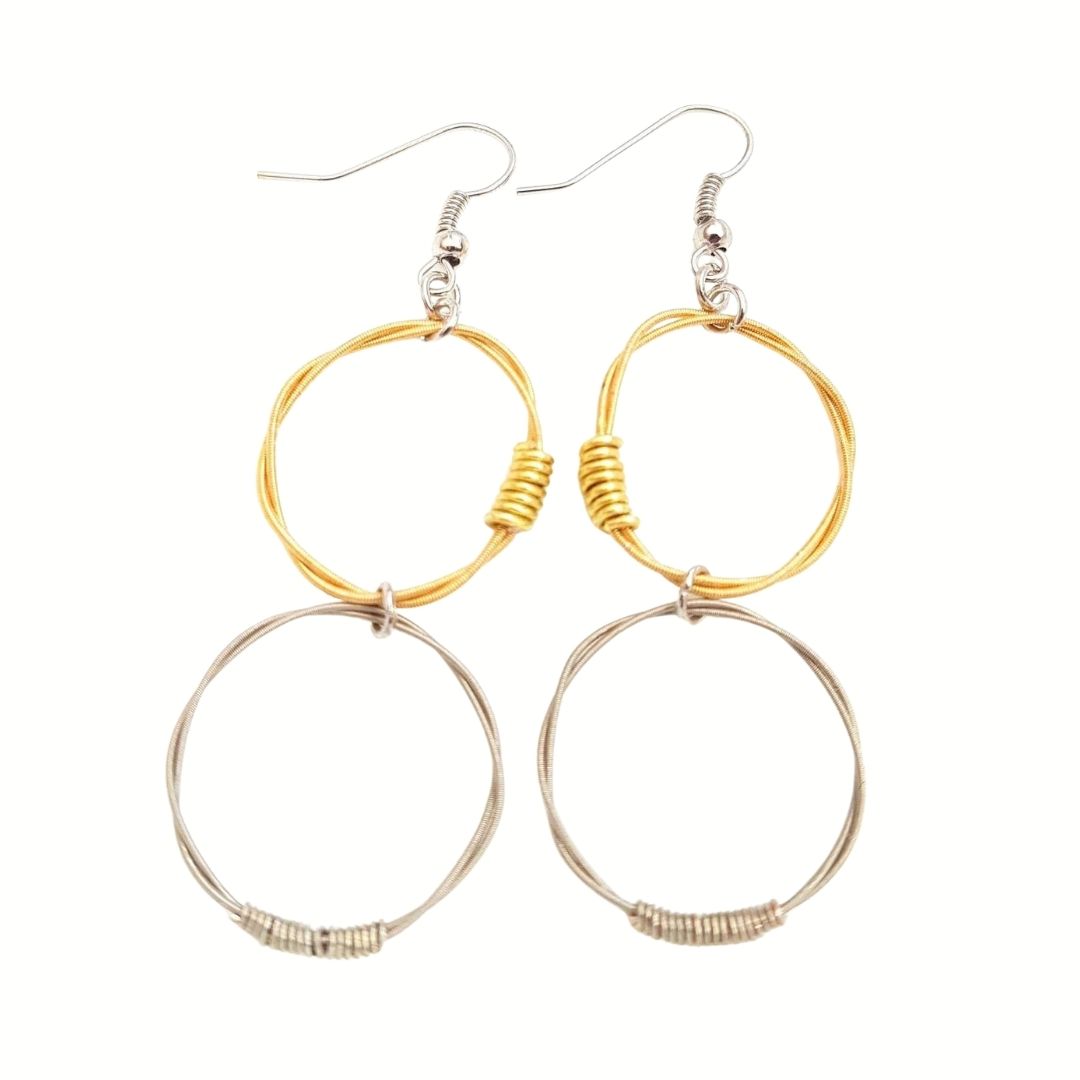 a pair of earrings with 2 hoops the top hoops are made from gold coloured guitar strings and the bottom ones are made from silver coloured guitar strings - white background