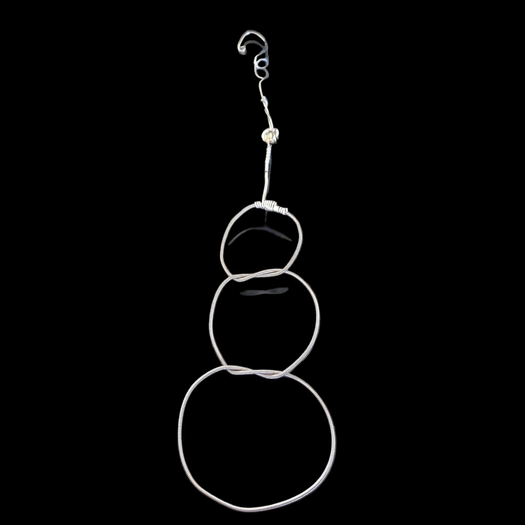 Christmas ornament in the shape of a snowman, made from an upcycled guitar string 