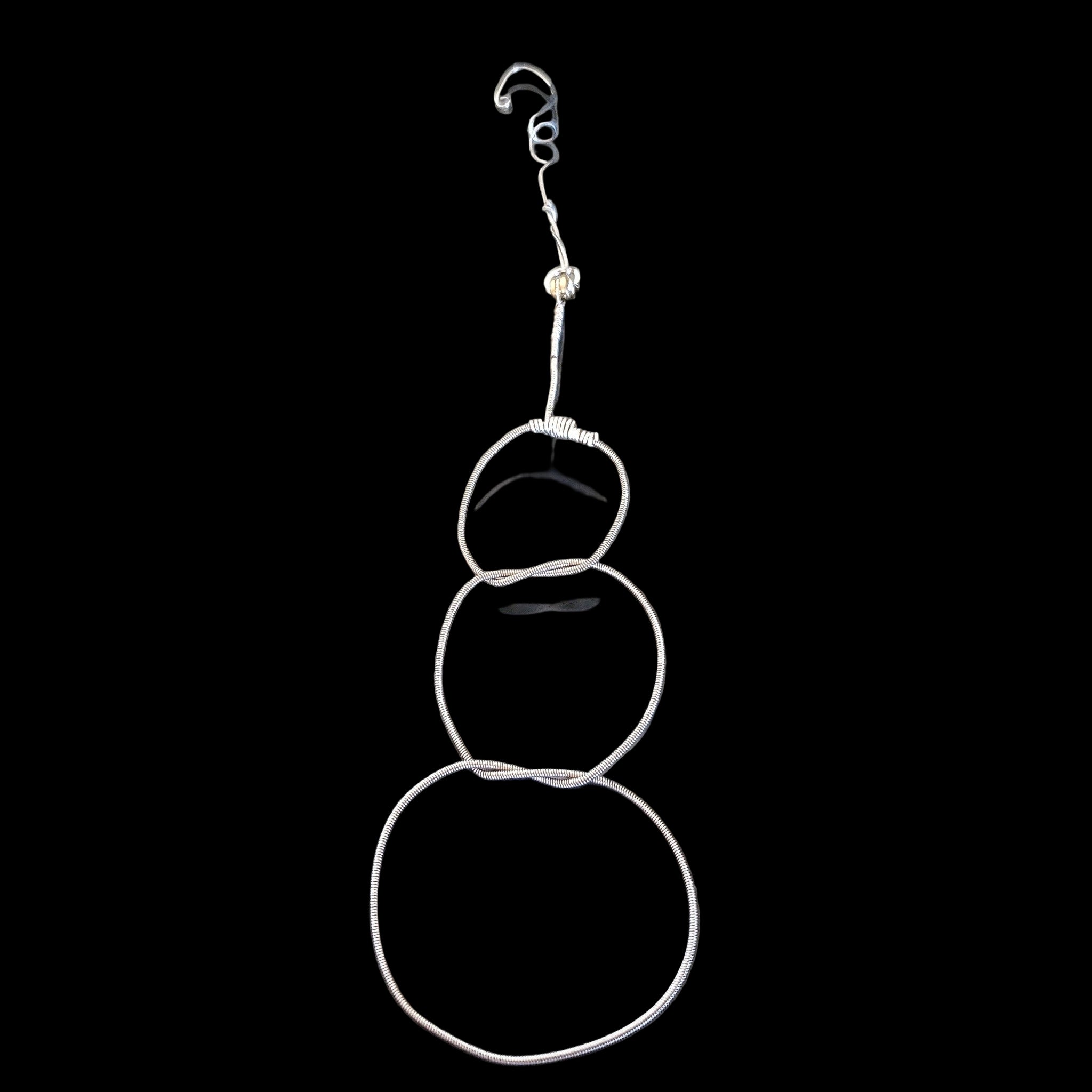 Christmas ornament in the shape of a snowman, made from an upcycled guitar string 