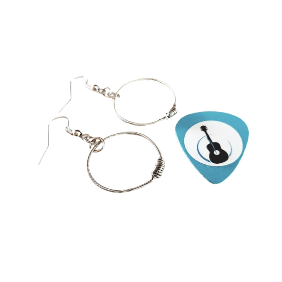 small hoop style earrings made from upcycled guitar strings in on the right of the two is a blue guitar pick with an image of a black guitar white background